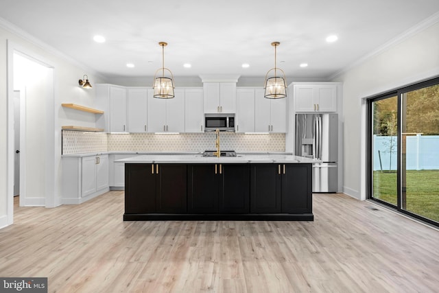 kitchen with stainless steel appliances, hanging light fixtures, a kitchen island with sink, and white cabinets