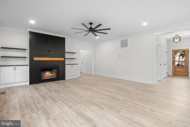 unfurnished living room with light hardwood / wood-style floors, ornamental molding, a large fireplace, and ceiling fan