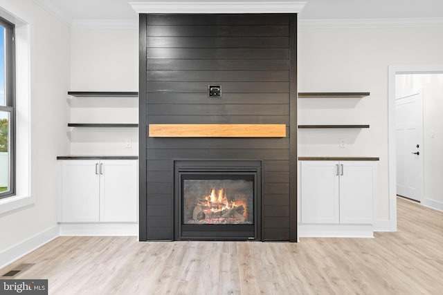 room details featuring crown molding, a fireplace, and hardwood / wood-style floors