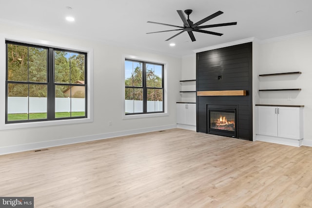 unfurnished living room with a fireplace, ornamental molding, light hardwood / wood-style floors, and ceiling fan