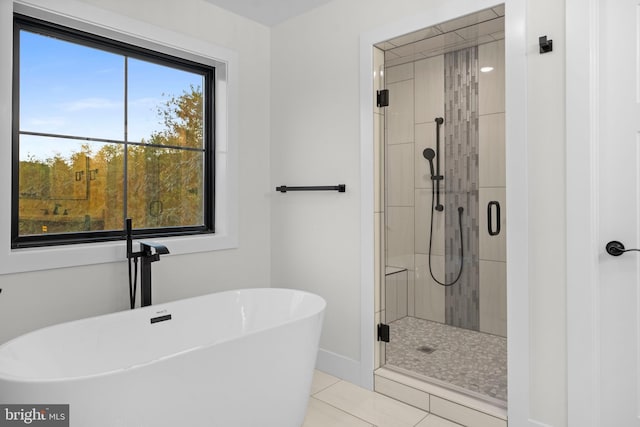 bathroom with tile patterned flooring and separate shower and tub