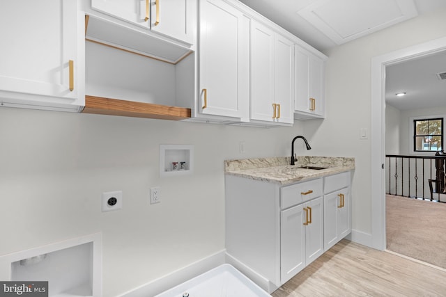 washroom with sink, cabinets, washer hookup, hookup for an electric dryer, and light wood-type flooring