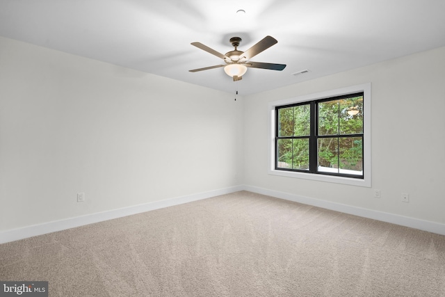 carpeted spare room featuring ceiling fan