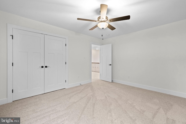 unfurnished bedroom featuring light colored carpet, ceiling fan, and a closet