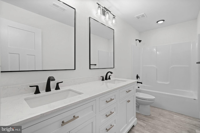 full bathroom with shower / bathing tub combination, vanity, wood-type flooring, and toilet