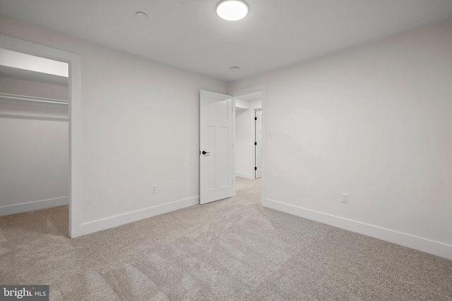 unfurnished bedroom with a closet and light carpet