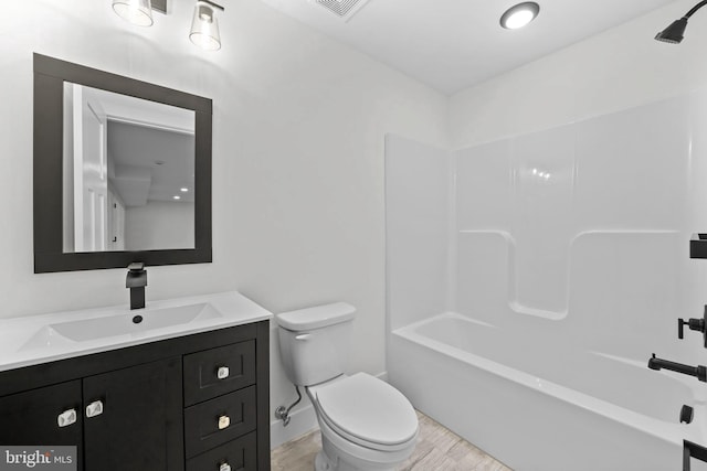 full bathroom featuring vanity, hardwood / wood-style floors, shower / bathtub combination, and toilet