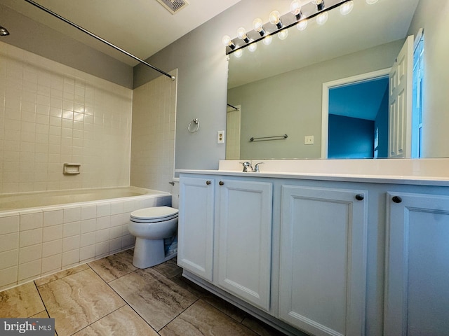 full bathroom with vanity, tiled shower / bath, and toilet