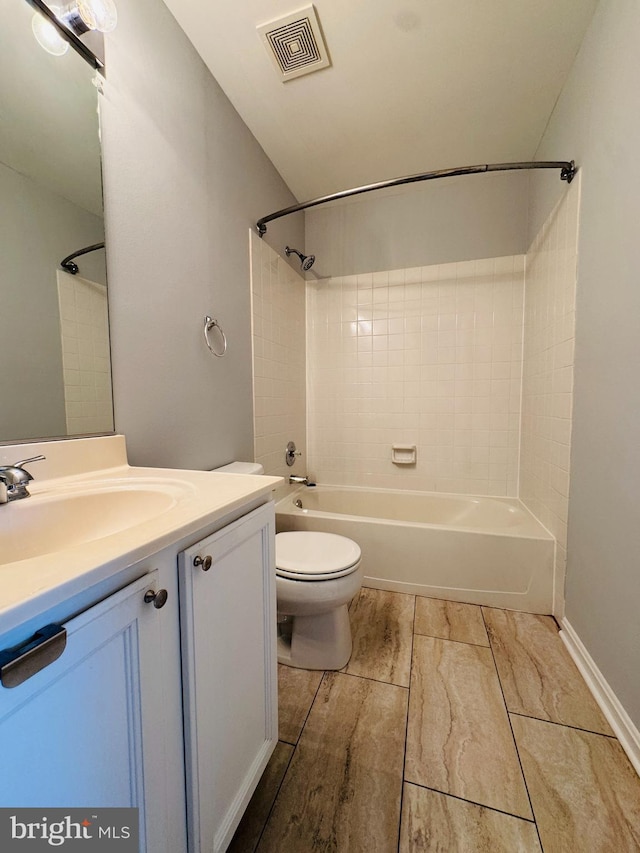 full bathroom featuring tiled shower / bath, vanity, and toilet