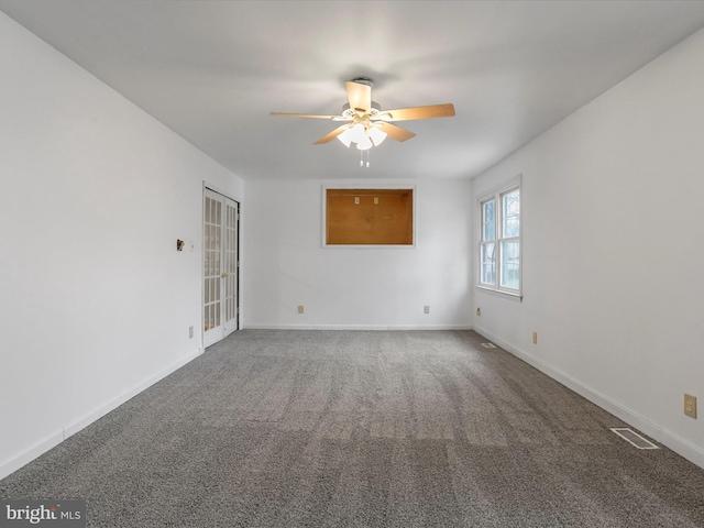 carpeted spare room featuring ceiling fan