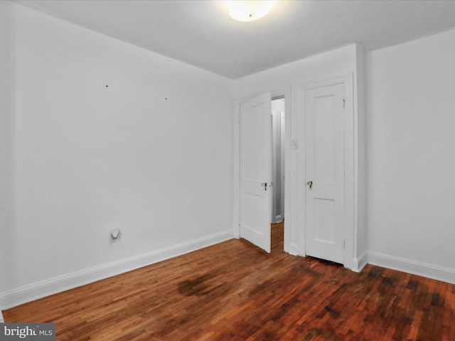 unfurnished bedroom with dark hardwood / wood-style floors