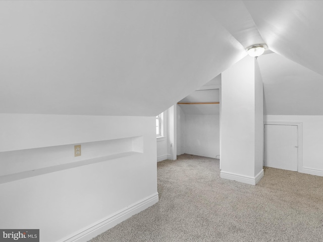 additional living space with lofted ceiling and light colored carpet