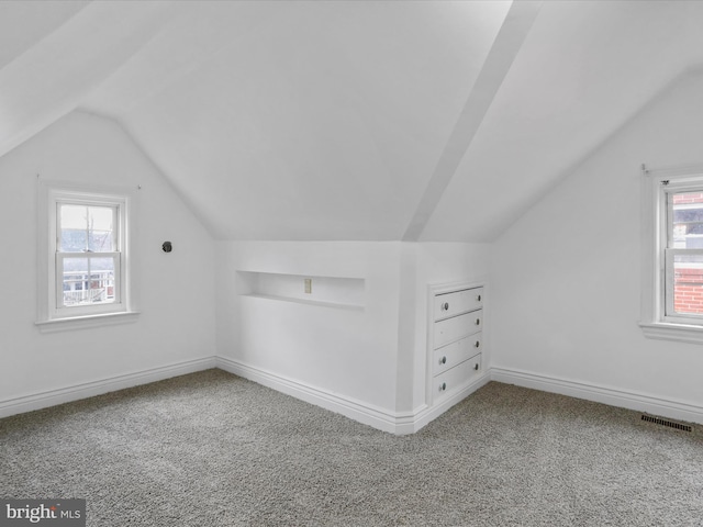 bonus room with lofted ceiling and carpet floors