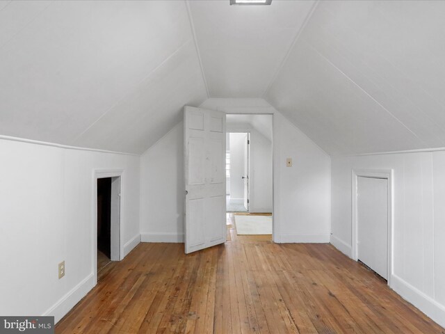 bonus room featuring lofted ceiling and light hardwood / wood-style floors