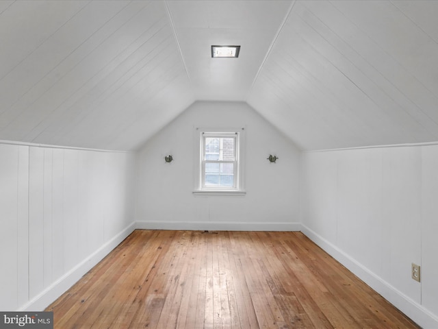 bonus room with lofted ceiling and light wood-type flooring