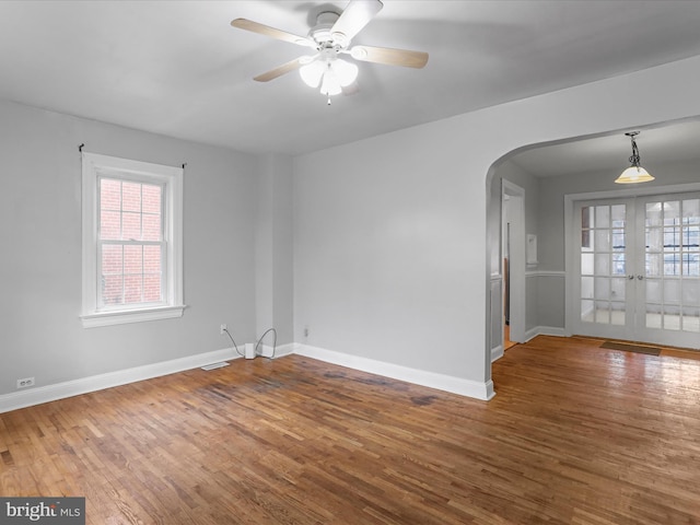 empty room featuring hardwood / wood-style flooring, french doors, and ceiling fan