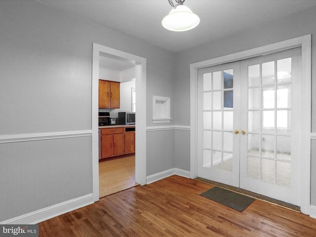 unfurnished dining area with french doors and light wood-type flooring