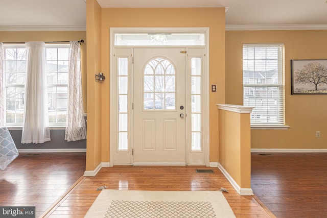 foyer entrance with hardwood / wood-style flooring and crown molding