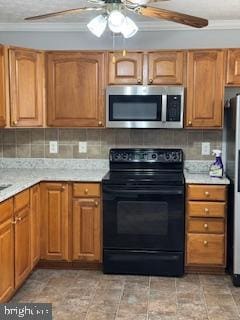 kitchen featuring tasteful backsplash, crown molding, stainless steel appliances, and ceiling fan