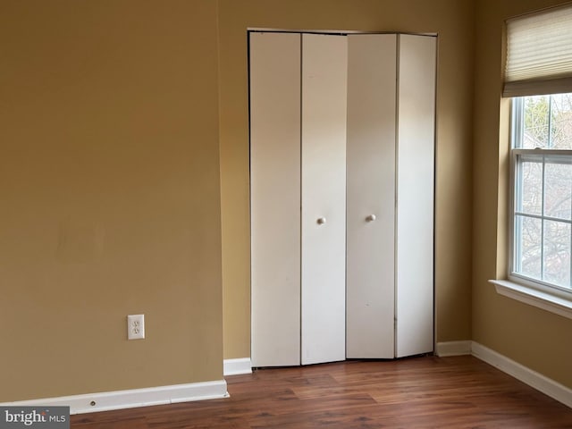 unfurnished bedroom featuring hardwood / wood-style flooring and a closet