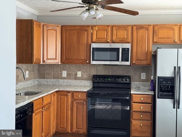 kitchen featuring black appliances, sink, decorative backsplash, light stone counters, and ceiling fan