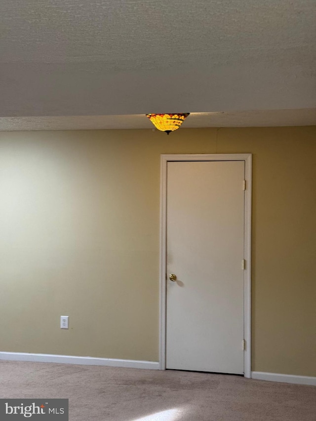 empty room featuring a textured ceiling and carpet