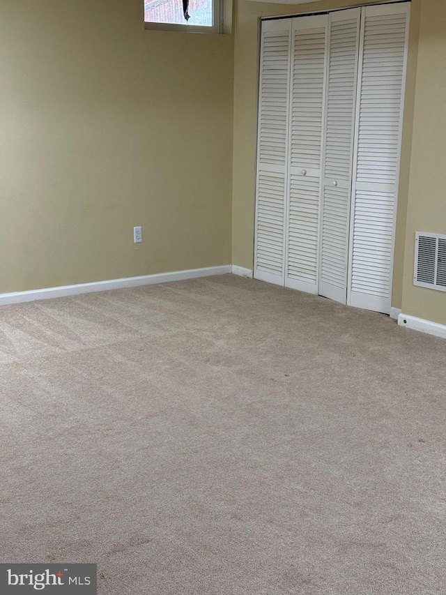 unfurnished bedroom with light carpet and a closet