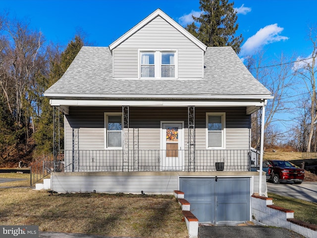 bungalow-style home featuring a garage and covered porch