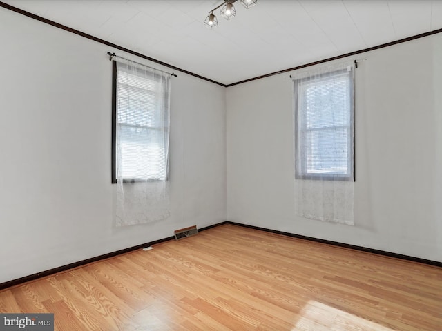 unfurnished room featuring crown molding and light hardwood / wood-style flooring