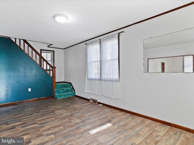 unfurnished room featuring wood-type flooring and ornamental molding