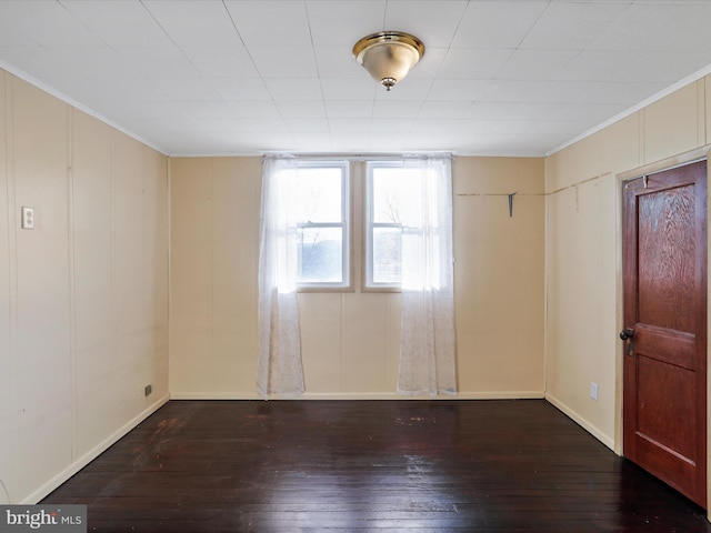 spare room featuring crown molding and dark hardwood / wood-style floors