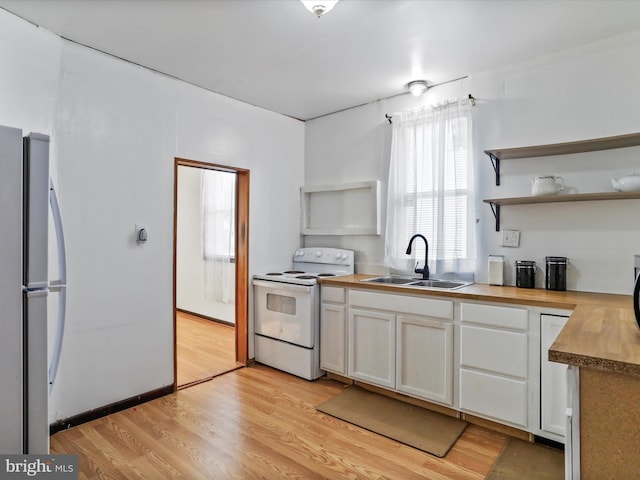 kitchen with wood counters, sink, white cabinetry, white electric stove, and stainless steel fridge