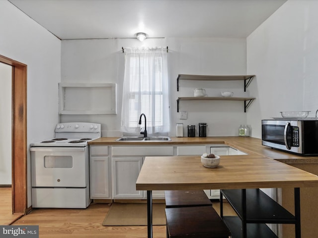 kitchen featuring butcher block countertops, sink, light hardwood / wood-style floors, and electric stove