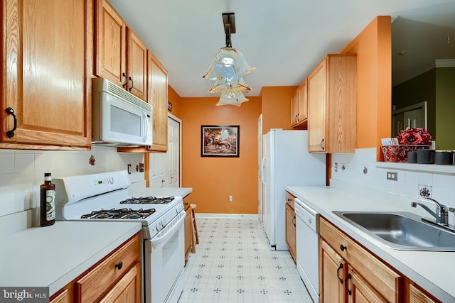 kitchen with tasteful backsplash, sink, white appliances, and decorative light fixtures