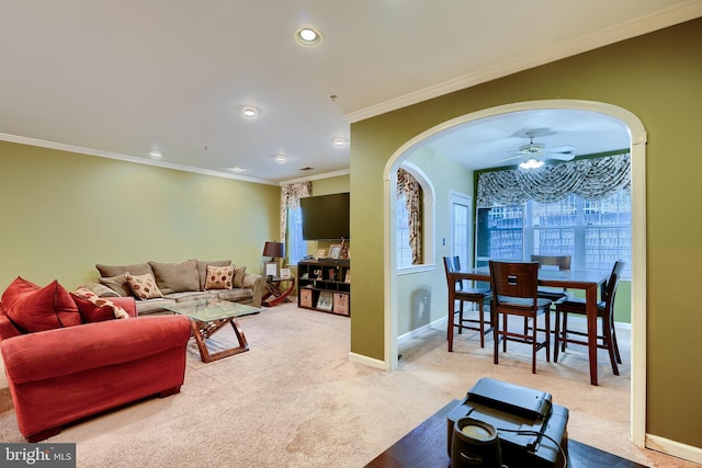 carpeted living room with crown molding and ceiling fan