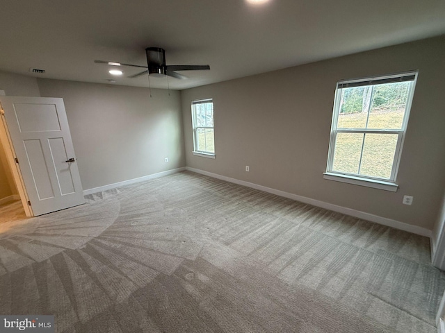 carpeted spare room featuring ceiling fan