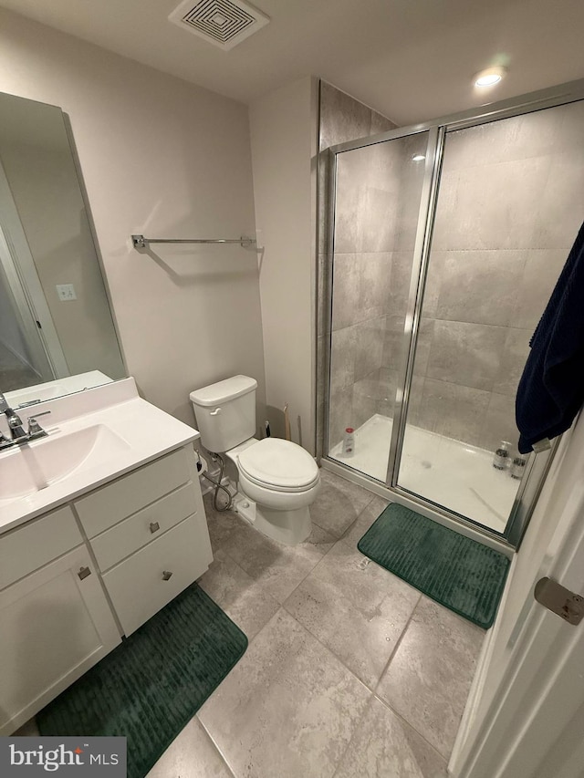 bathroom featuring vanity, toilet, and walk in shower