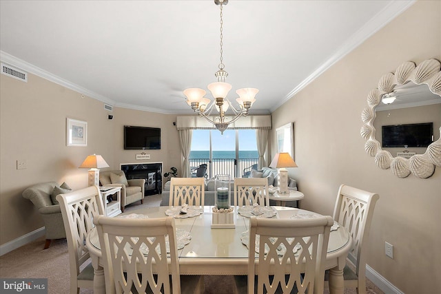 dining room with a notable chandelier, carpet floors, and ornamental molding