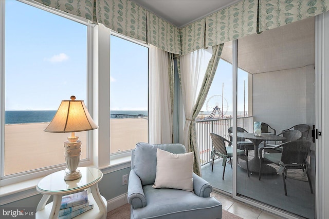 living area featuring a water view, a wealth of natural light, and light tile patterned floors