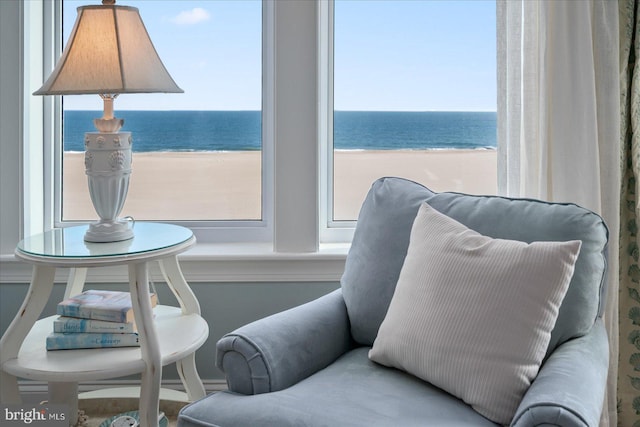 living area featuring a view of the beach and a water view