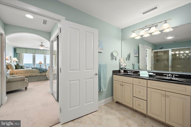 bathroom featuring ceiling fan, vanity, and a shower with door