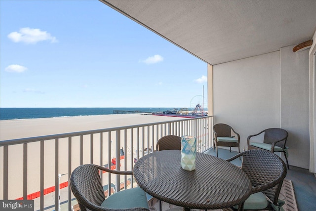 balcony featuring a water view and a beach view