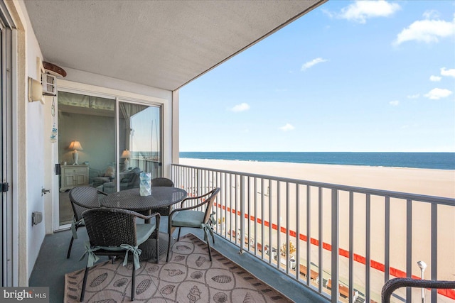 balcony with a water view and a view of the beach