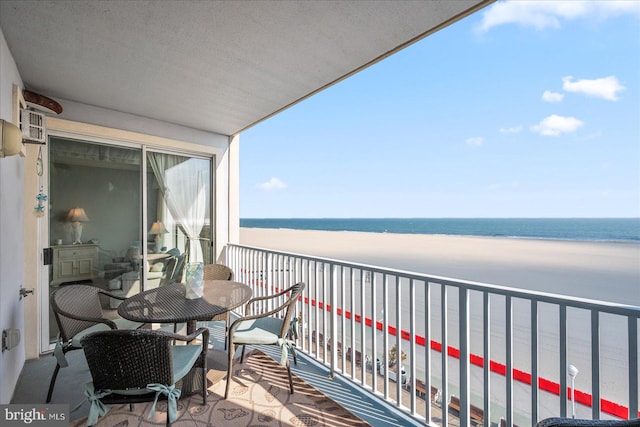 balcony with a water view and a view of the beach