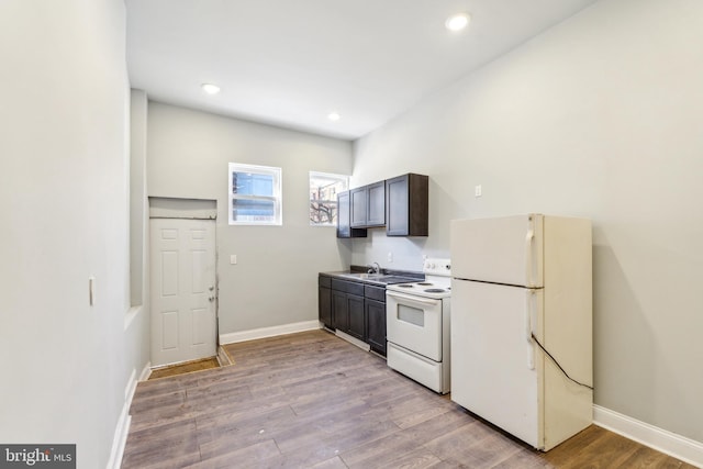 kitchen featuring dark brown cabinets, white appliances, and light hardwood / wood-style flooring