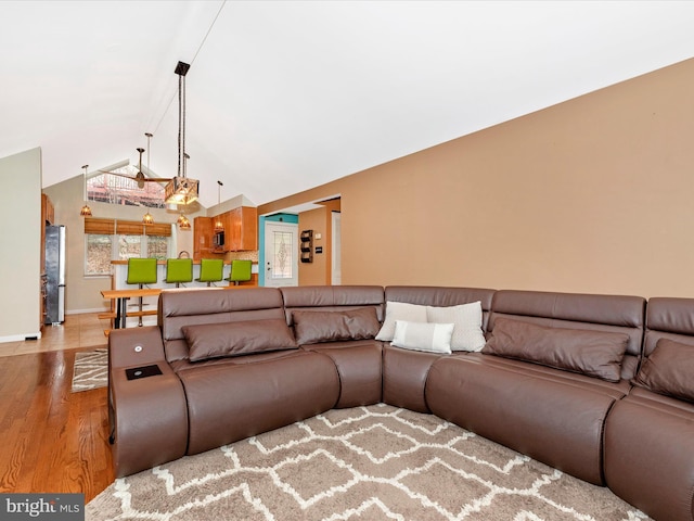 living room featuring vaulted ceiling and light hardwood / wood-style flooring