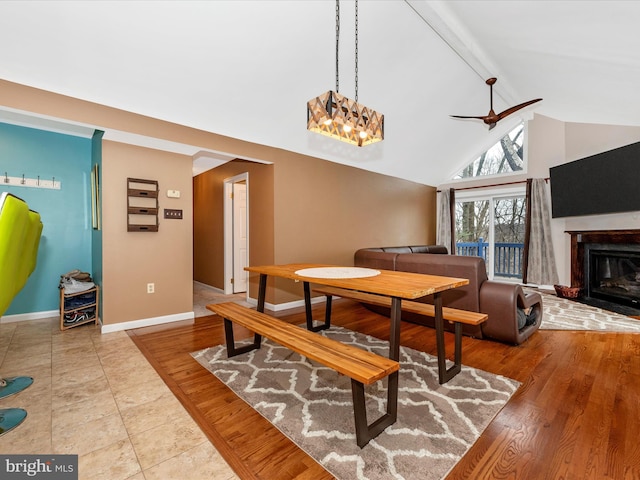 dining space with beamed ceiling, ceiling fan, high vaulted ceiling, and light hardwood / wood-style floors