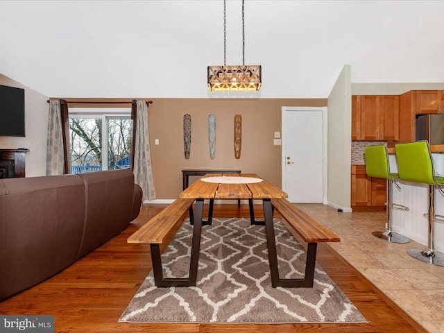 dining area featuring lofted ceiling and light hardwood / wood-style flooring