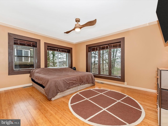 bedroom featuring multiple windows, crown molding, and wood-type flooring