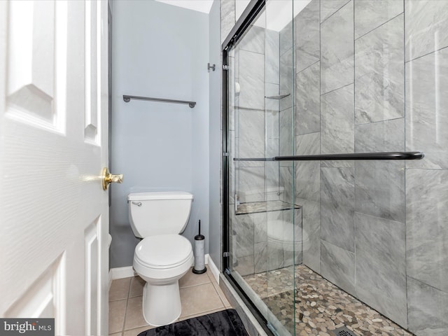 bathroom featuring tile patterned flooring, an enclosed shower, and toilet